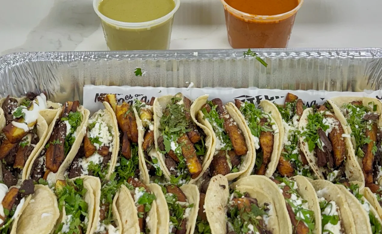 Assorted Mexican tacos with toppings and salsas on a table