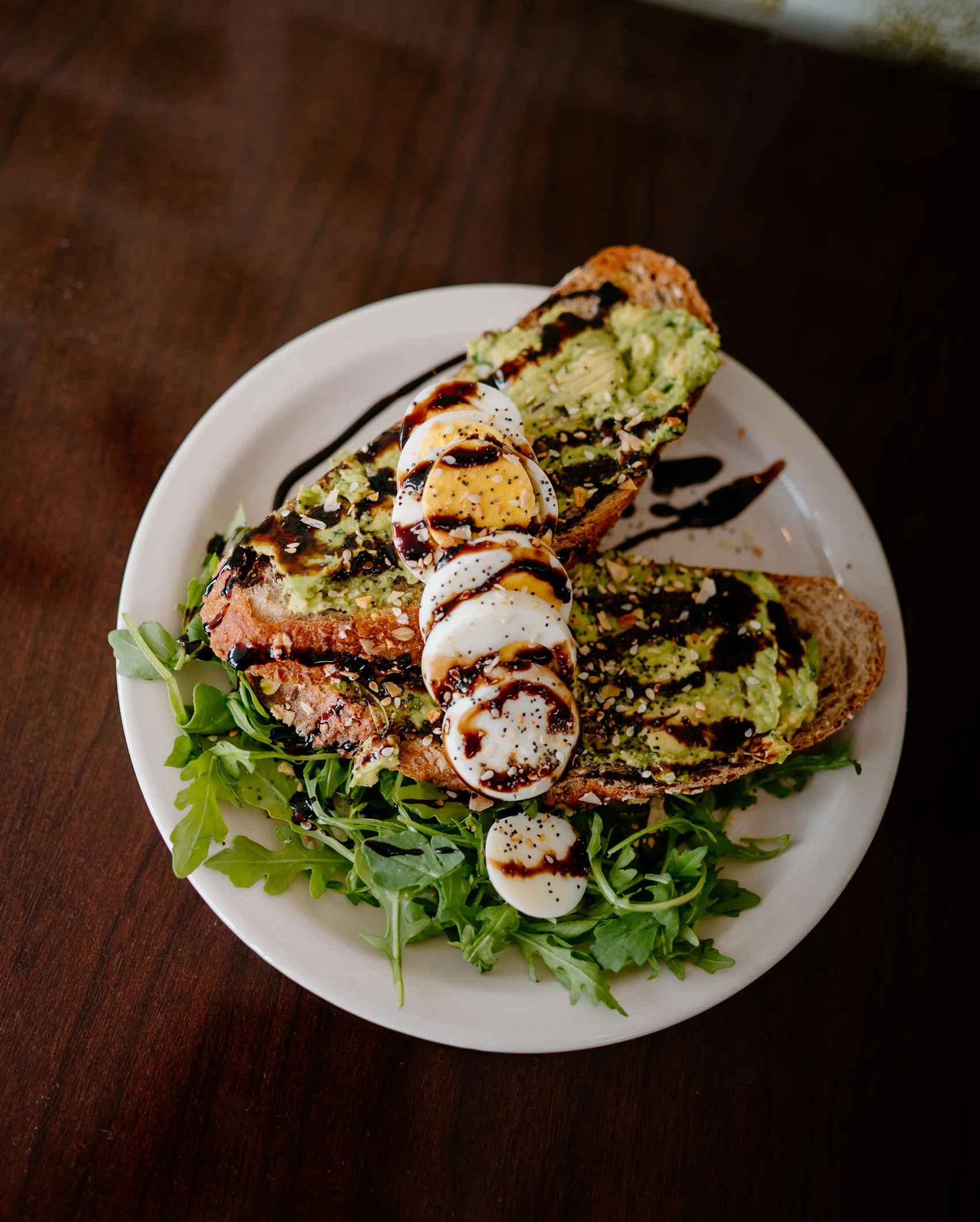 Avocado toast with poached eggs and balsamic glaze