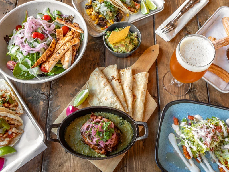 Colorful Mexican feast with tacos, guacamole, and grilled meats