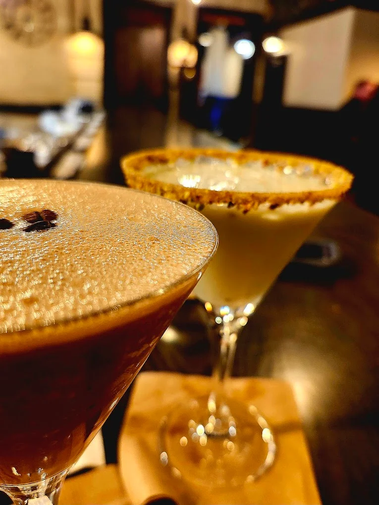 Two elegant cocktails on a bar counter