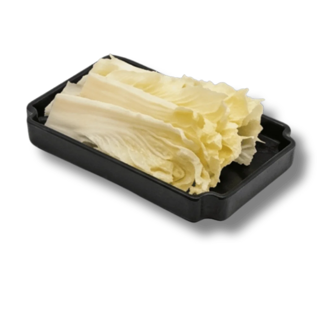 Freshly sliced napa cabbage on a black serving tray.