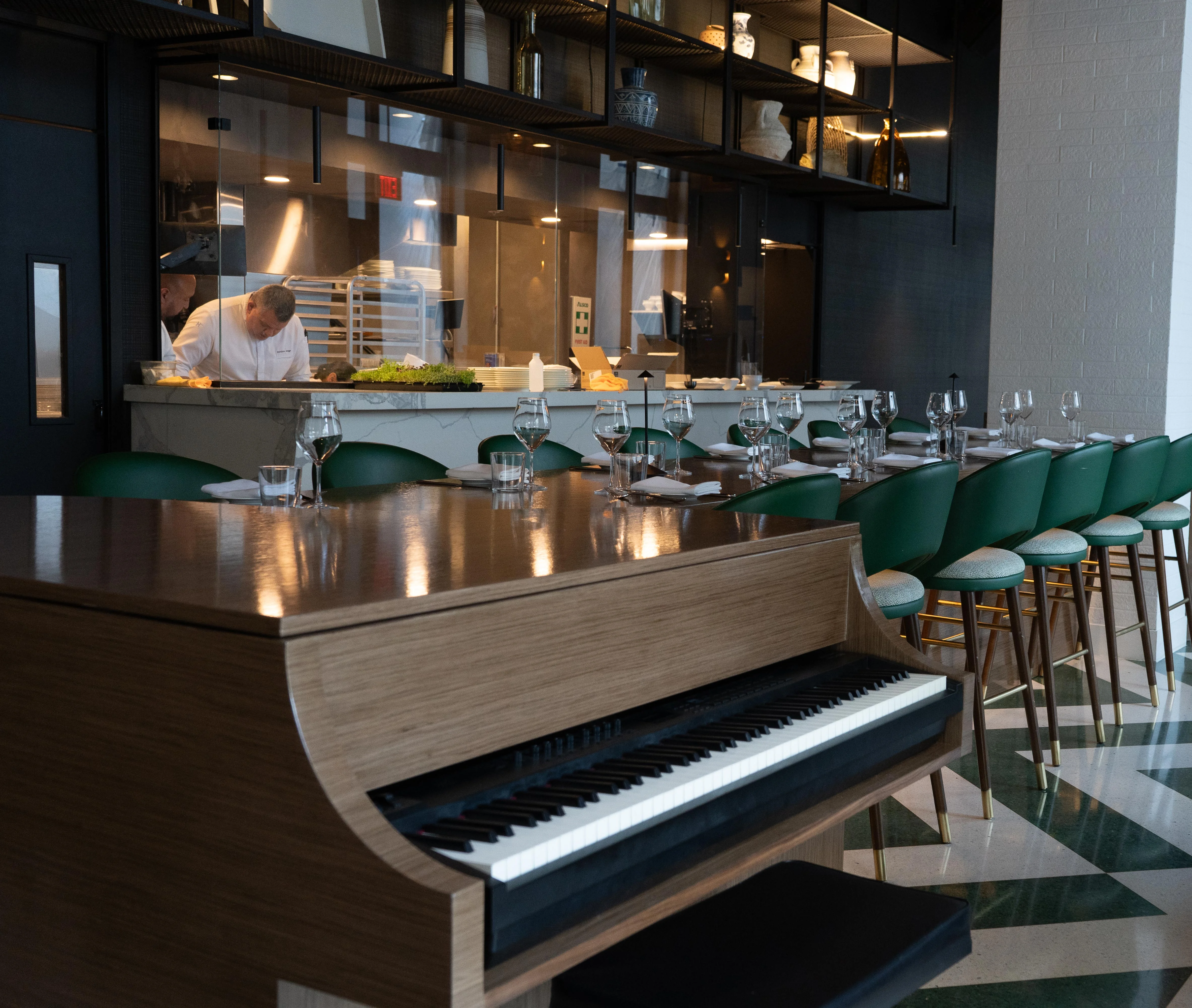 Modern restaurant interior with piano and open kitchen