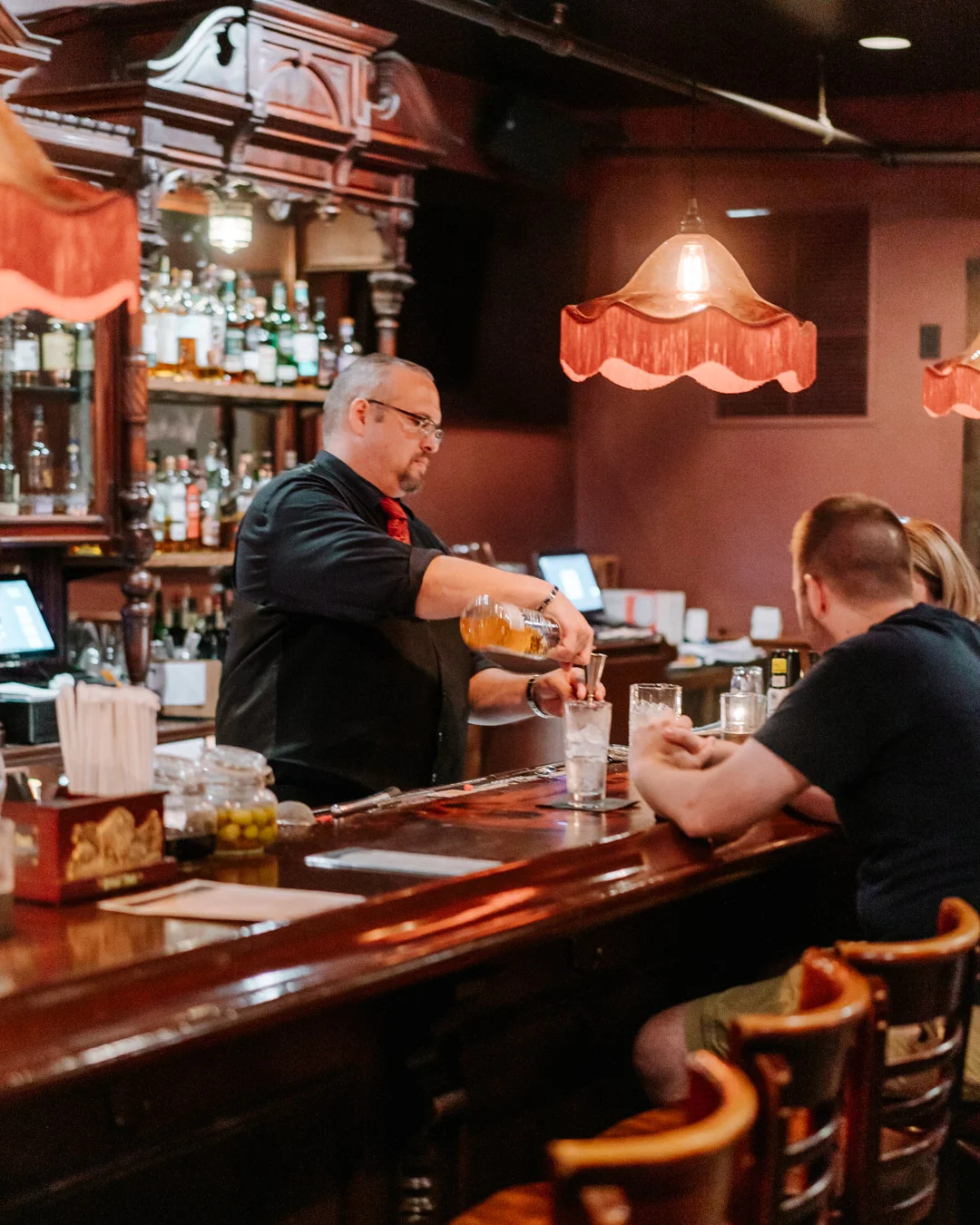 Bartender pouring a cocktail at a stylish bar
