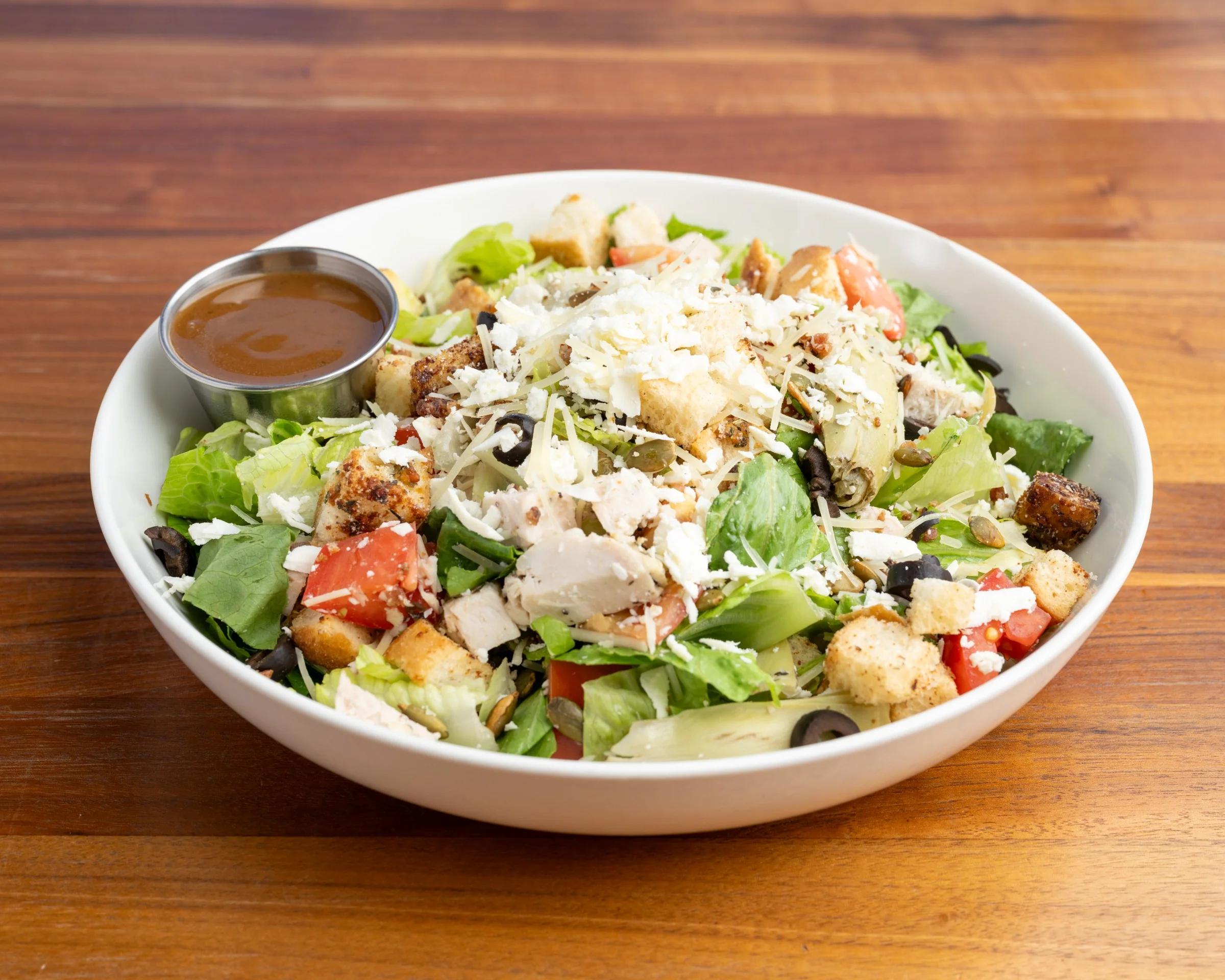 Fresh green salad with chicken, cheese, croutons, tomato, and dressing