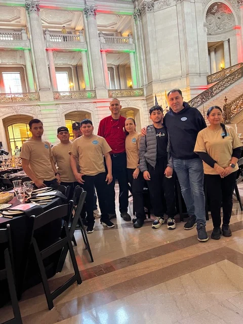 Restaurant staff posing in a grand dining hall