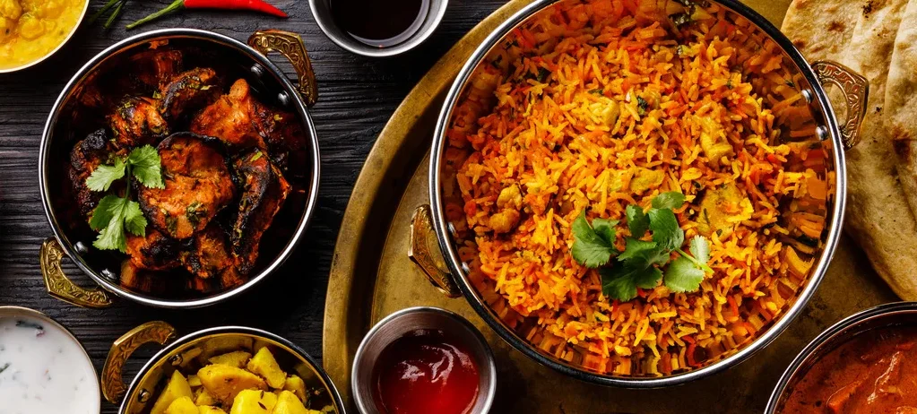 Indian thali featuring biryani, curries, and naan bread