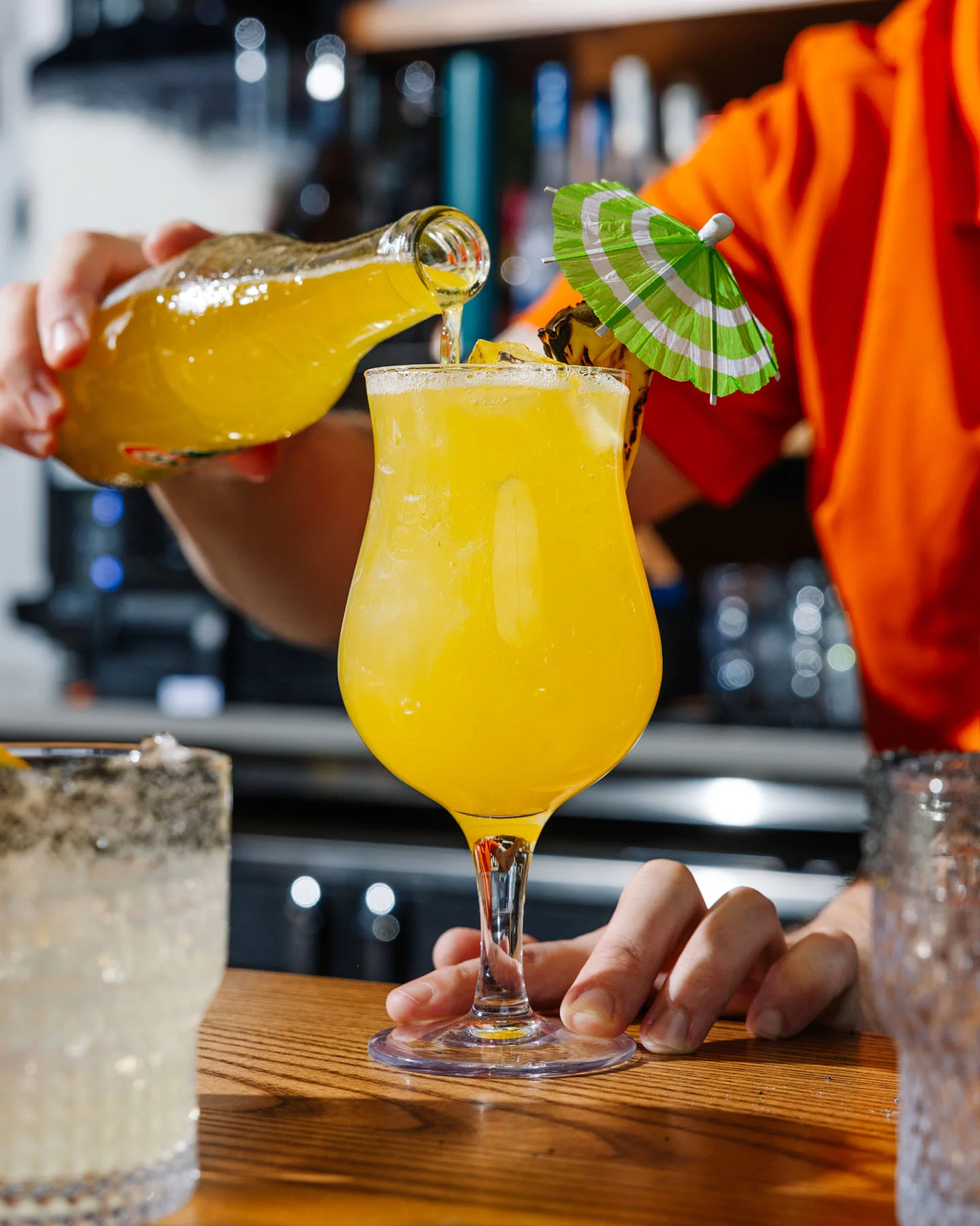 Colorful tropical cocktail being prepared at a bar