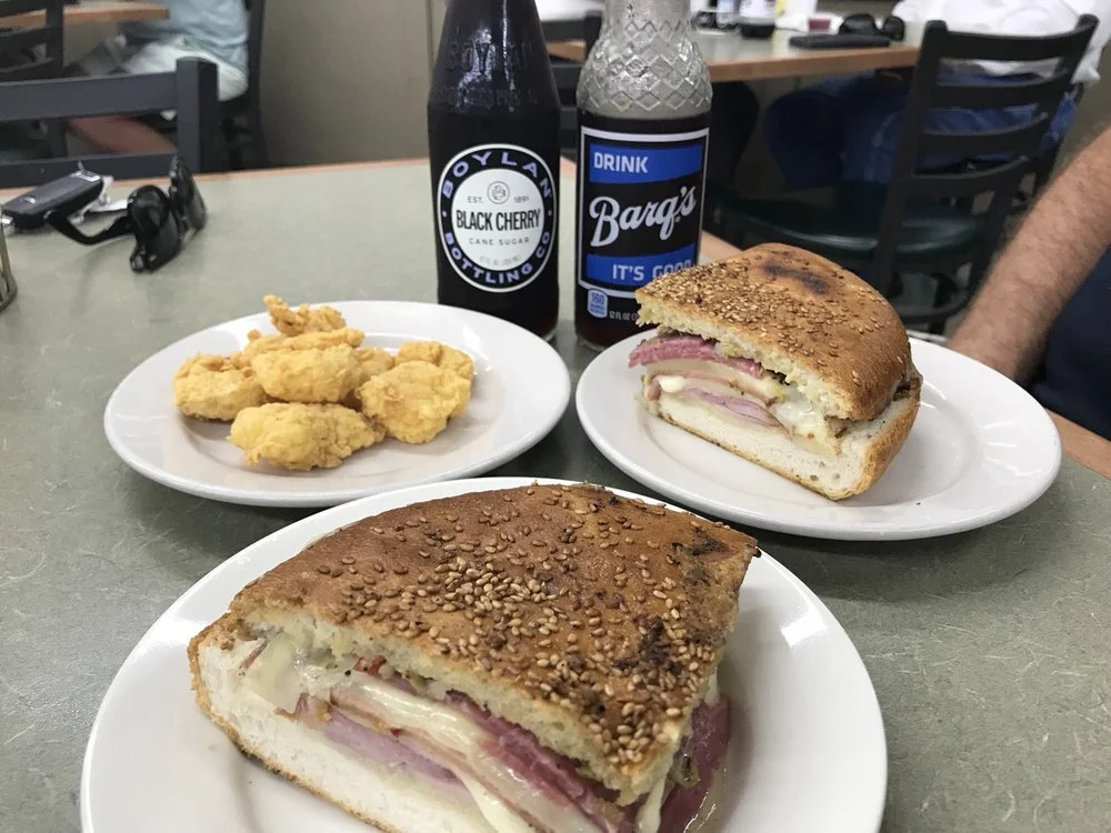 Cuban sandwich with ham and pickles served with fried snacks