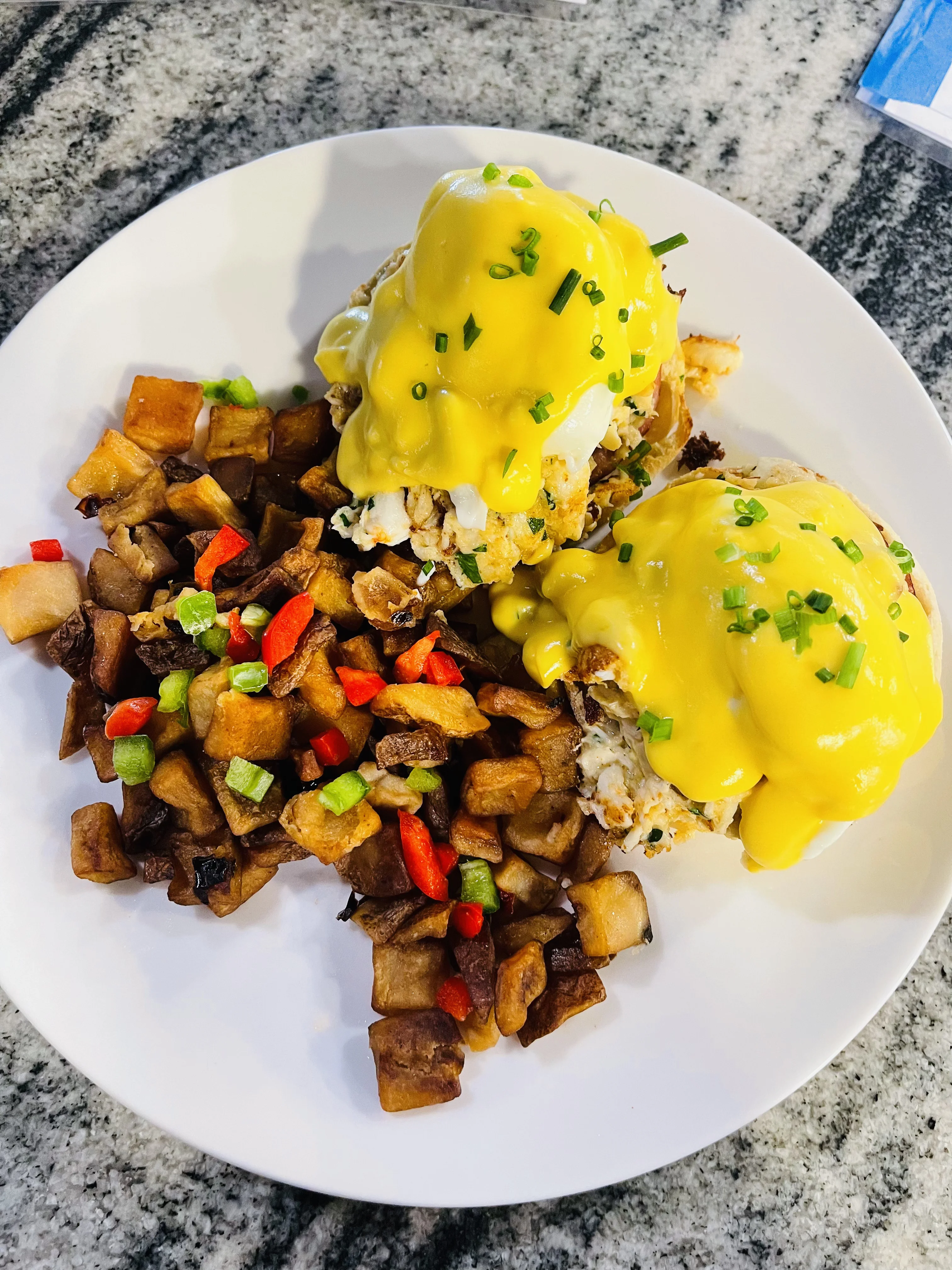 Crab eggs benedict with hollandaise sauce and home fries