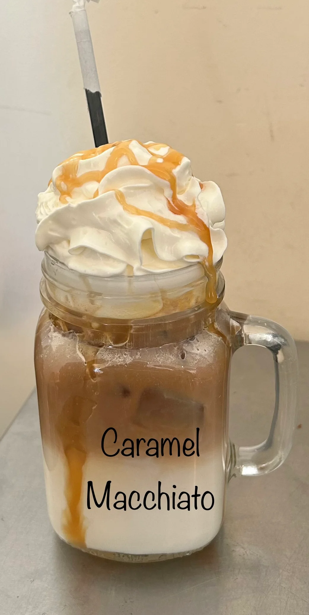 Iced caramel macchiato in a mason jar with whipped cream