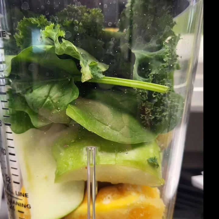 Fresh green smoothie ingredients in a blender for a healthy drink