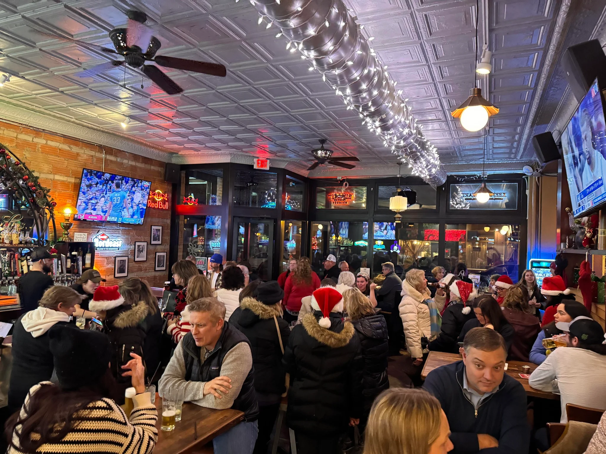 Lively bar interior decorated for the holidays with patrons enjoying drinks
