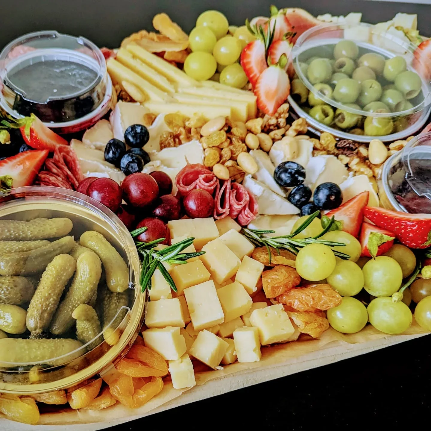 Artisan cheese and charcuterie board with fruits and pickles