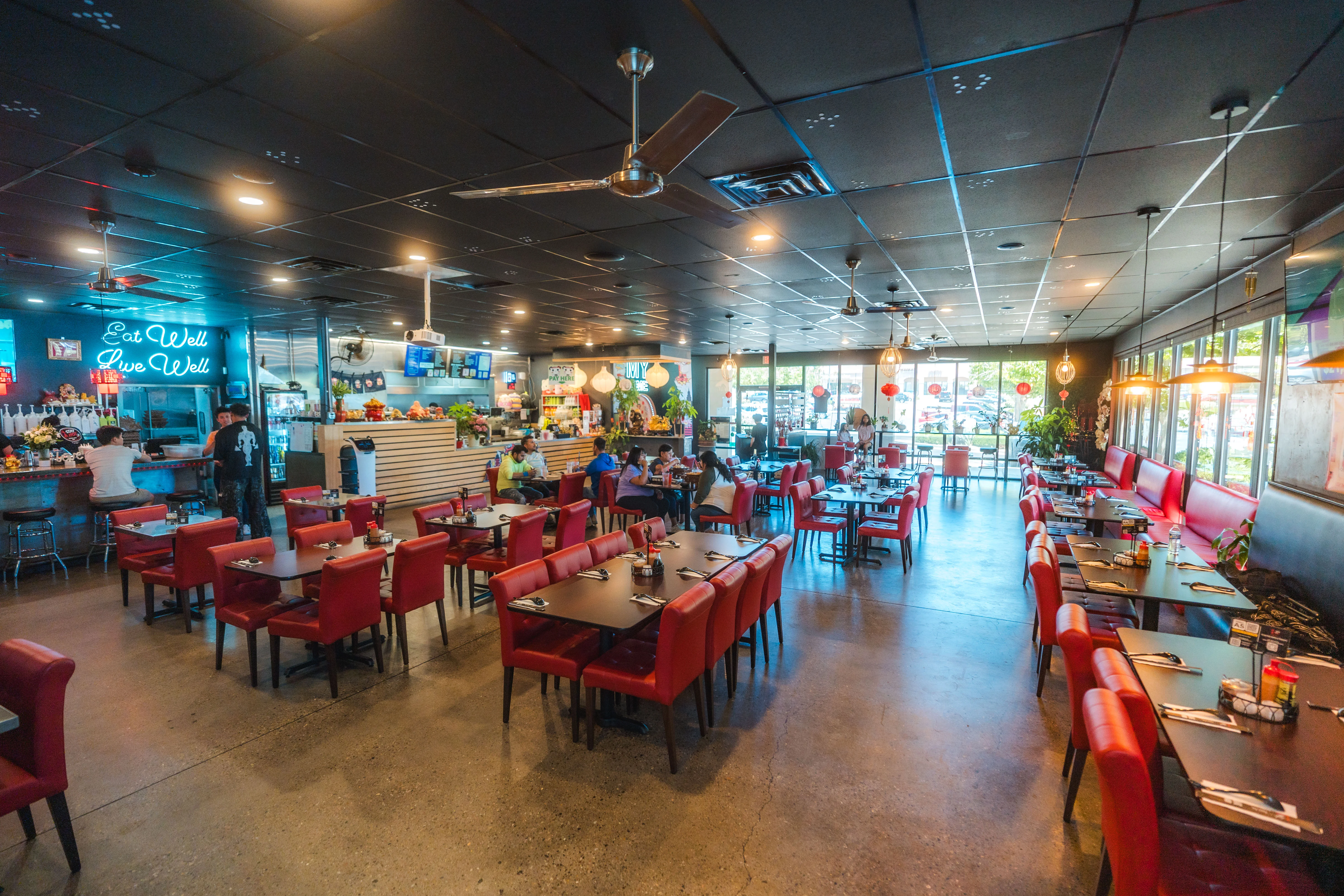 Vibrant restaurant interior with red seating and neon decor