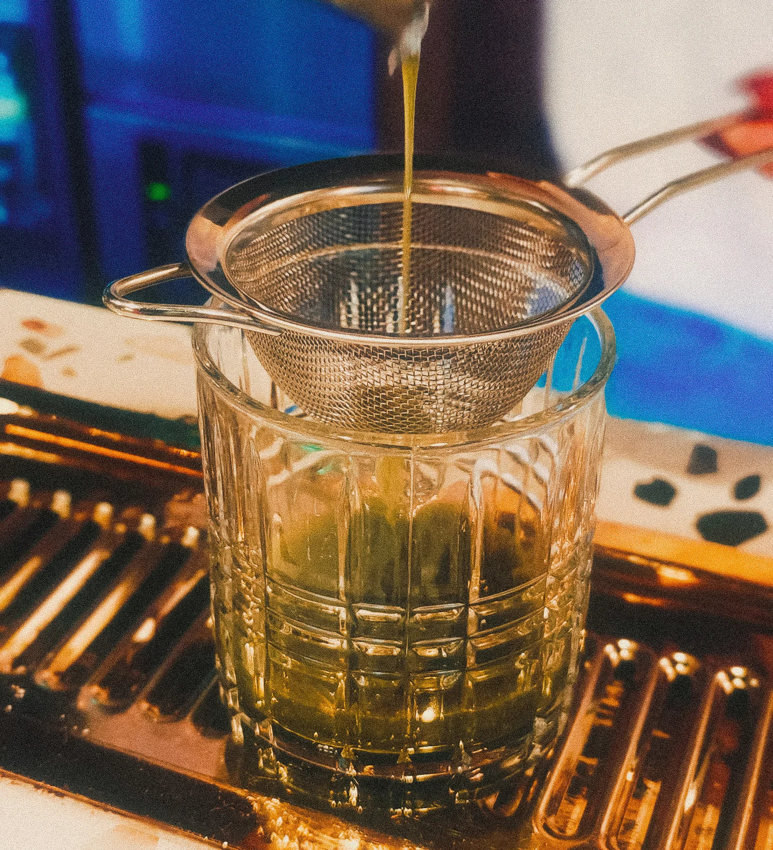 Straining matcha into a glass using a fine mesh sieve.