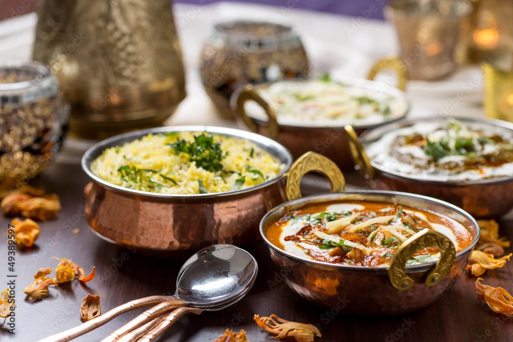 Indian curry dishes served in traditional copper bowls