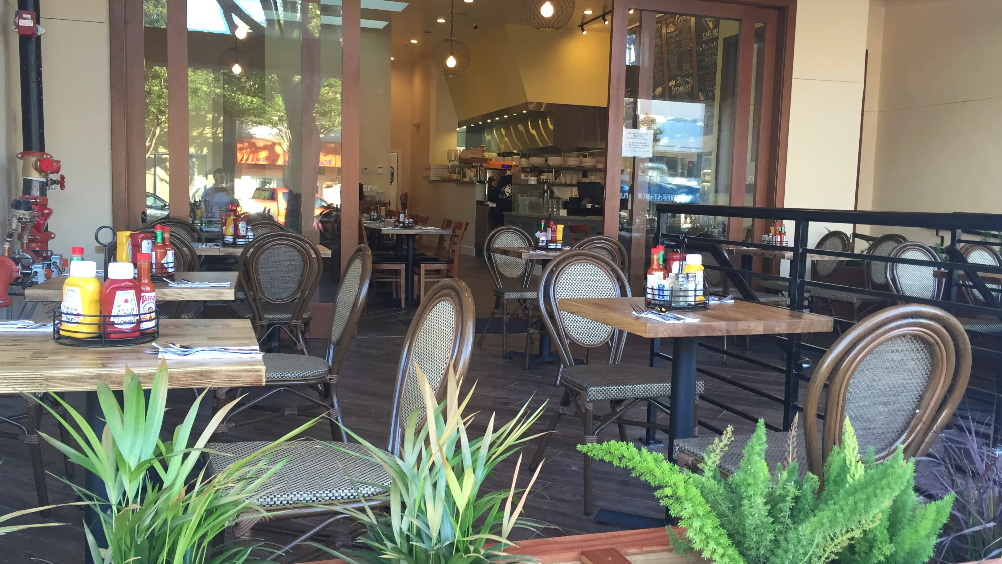 patio with tables, chairs, condiments, and green plants