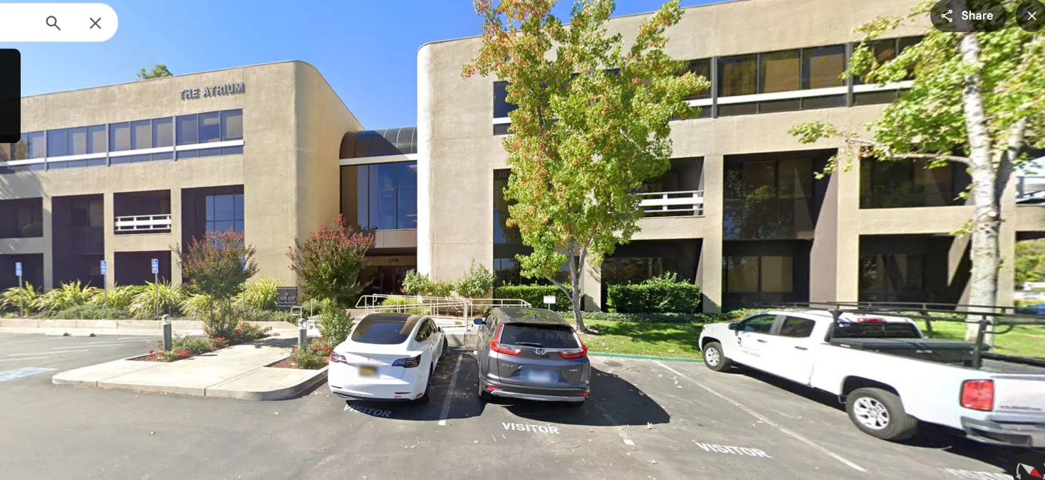 Google Street View image of an office building and parking lot