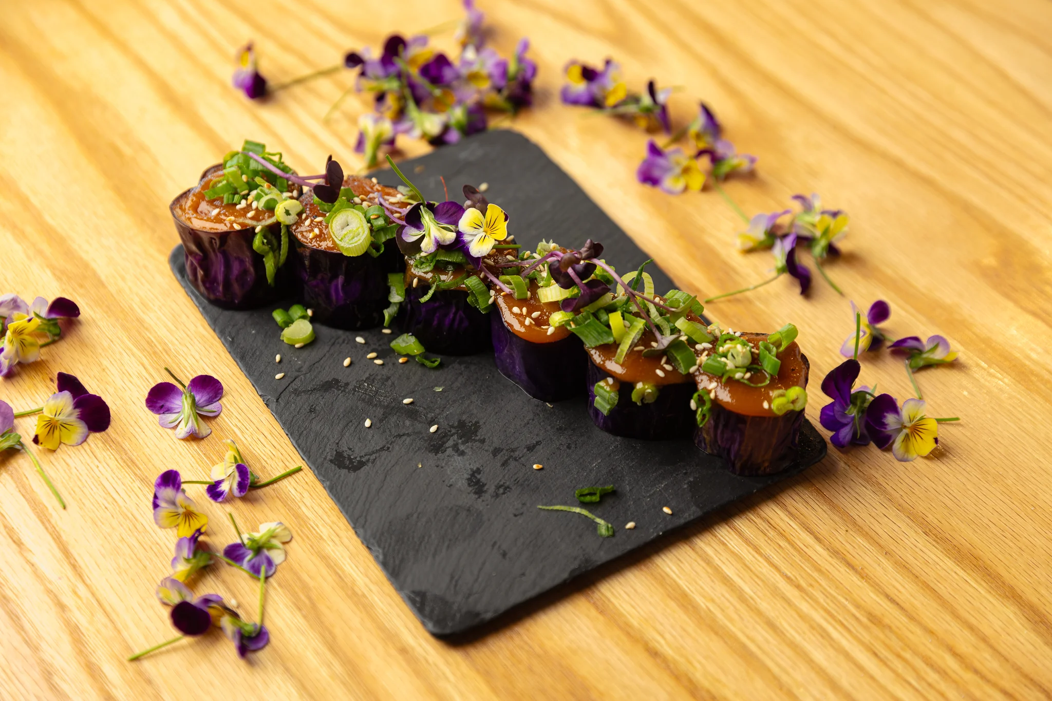 Japanese sushi rolls with edible flowers and green onions