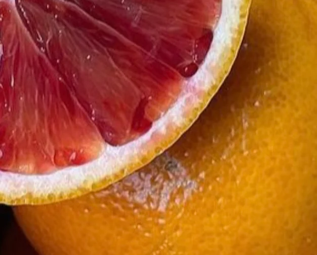 Fresh blood orange slice on vibrant orange background