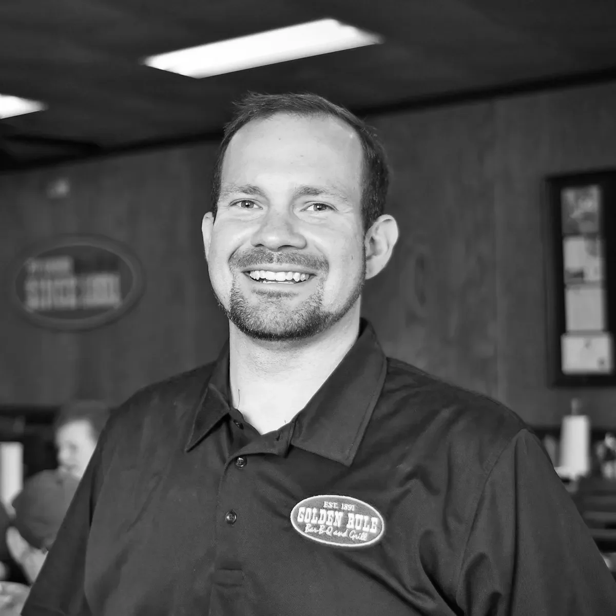 Smiling restaurant staff member in a cozy dining area