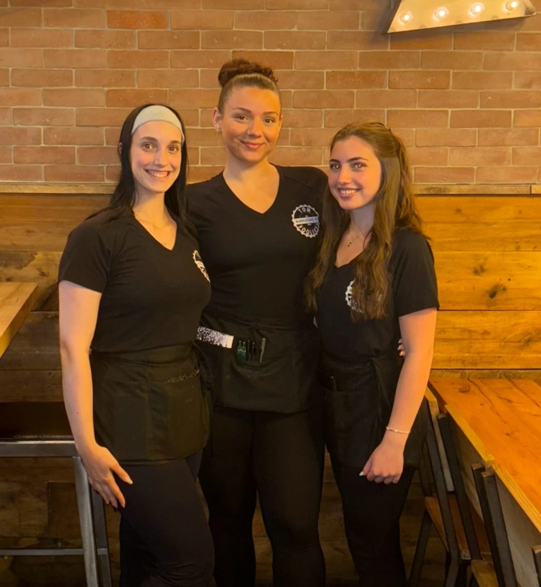 Friendly restaurant staff posing together in a cozy dining area