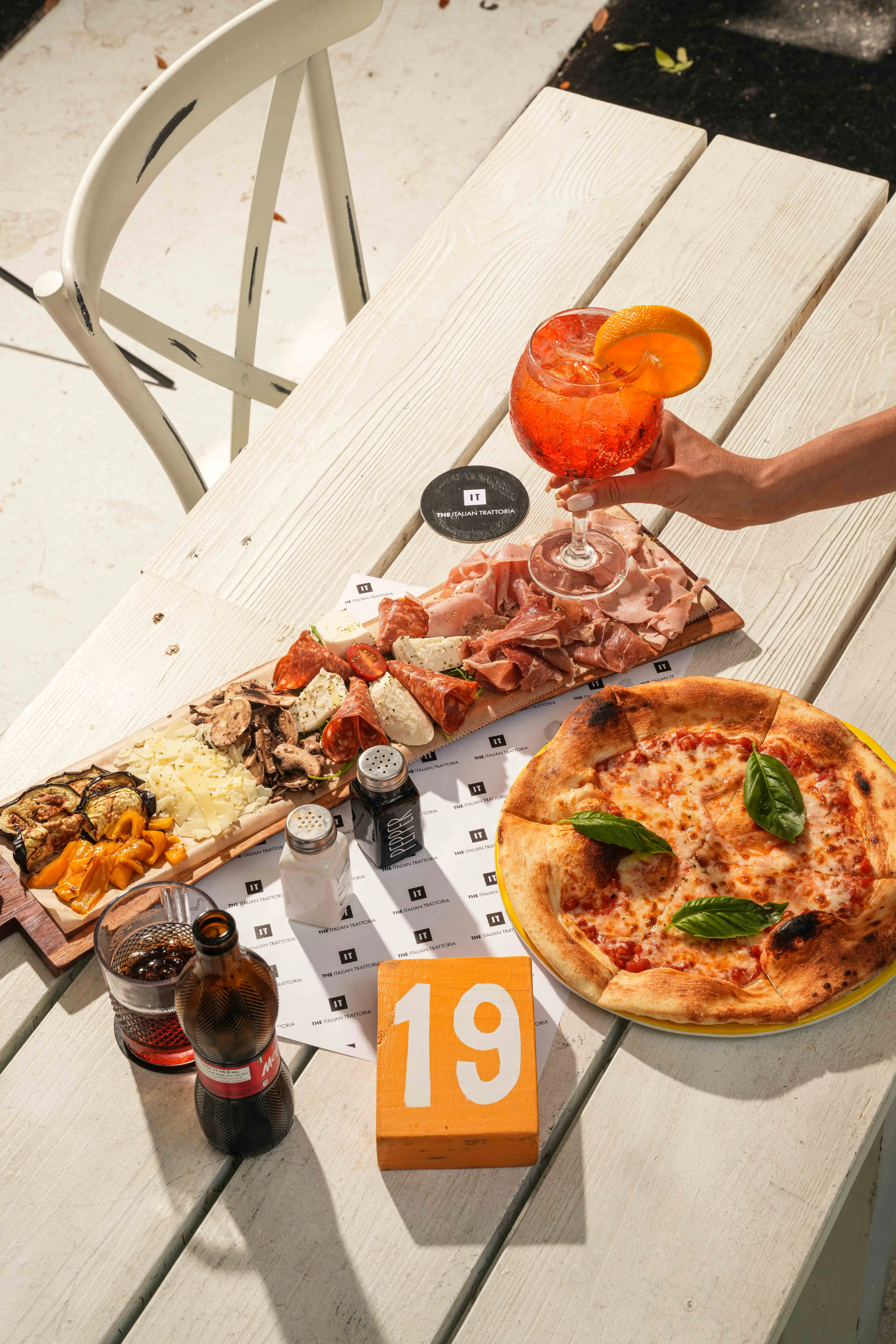Italian charcuterie board and Margherita pizza on a wooden table