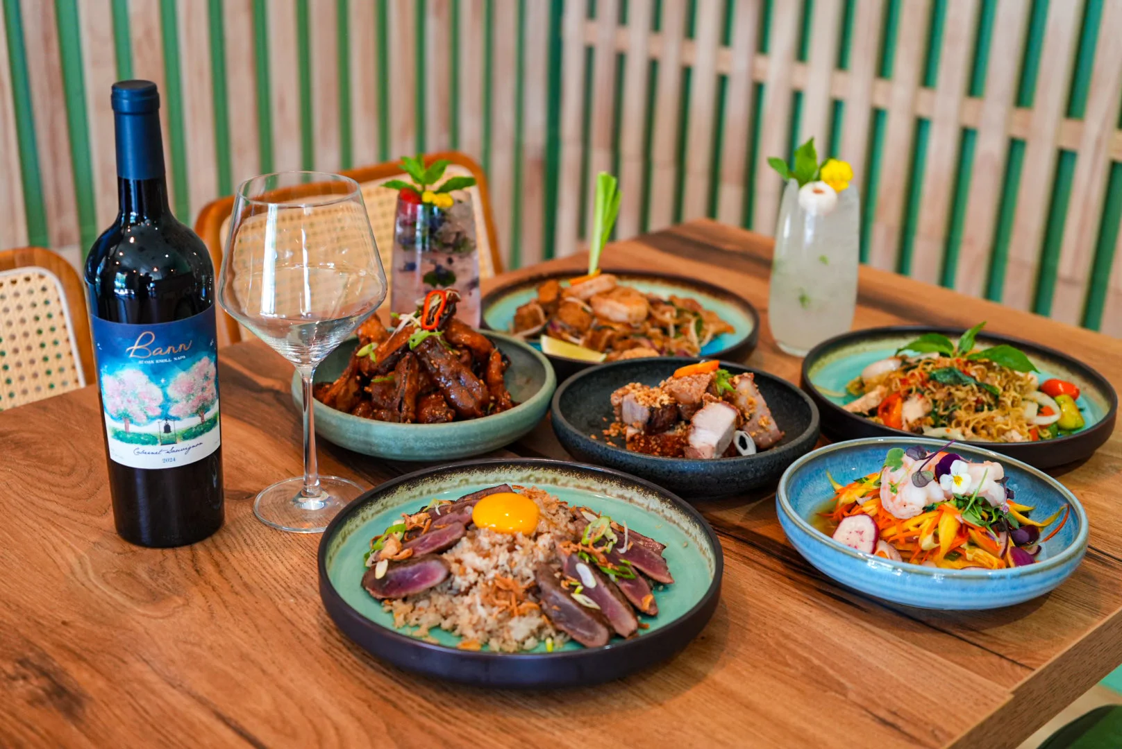 Assorted Asian dishes with wine in a modern restaurant setting