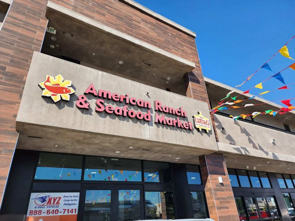 Exterior of American Ranch & Seafood Market with colorful flags