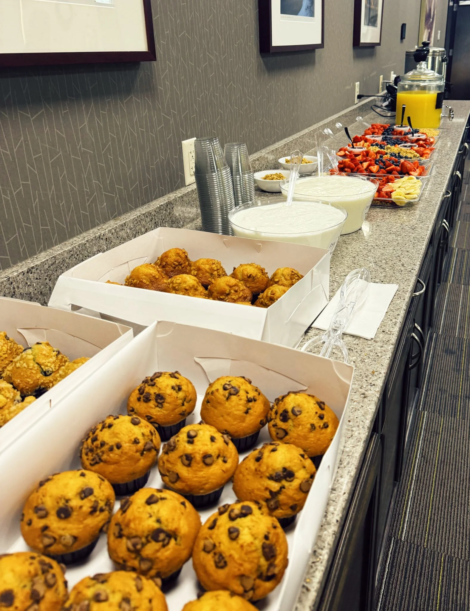 Assorted muffins and fresh fruit display for a breakfast buffet