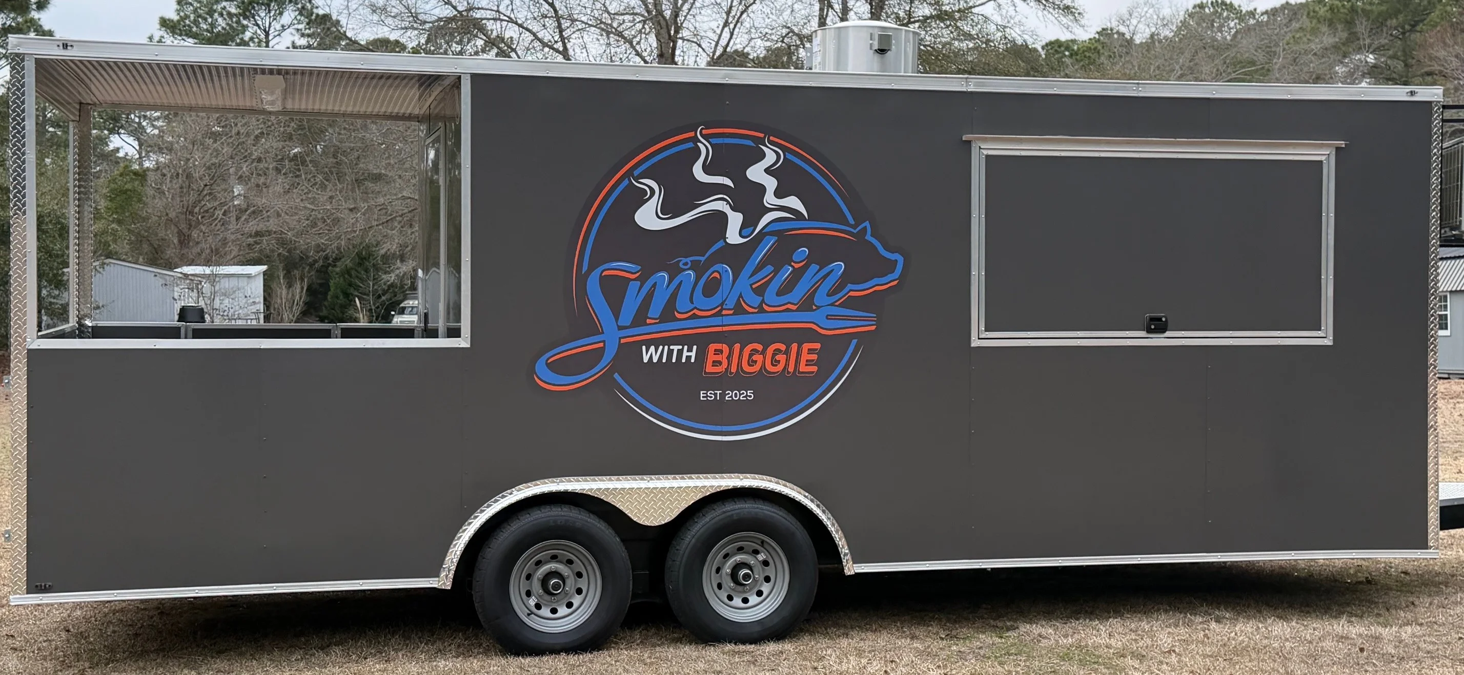 A vibrant logo featuring the text 'Smokin with Biggie' accompanied by a stylized image of a pig and smoke rising above.