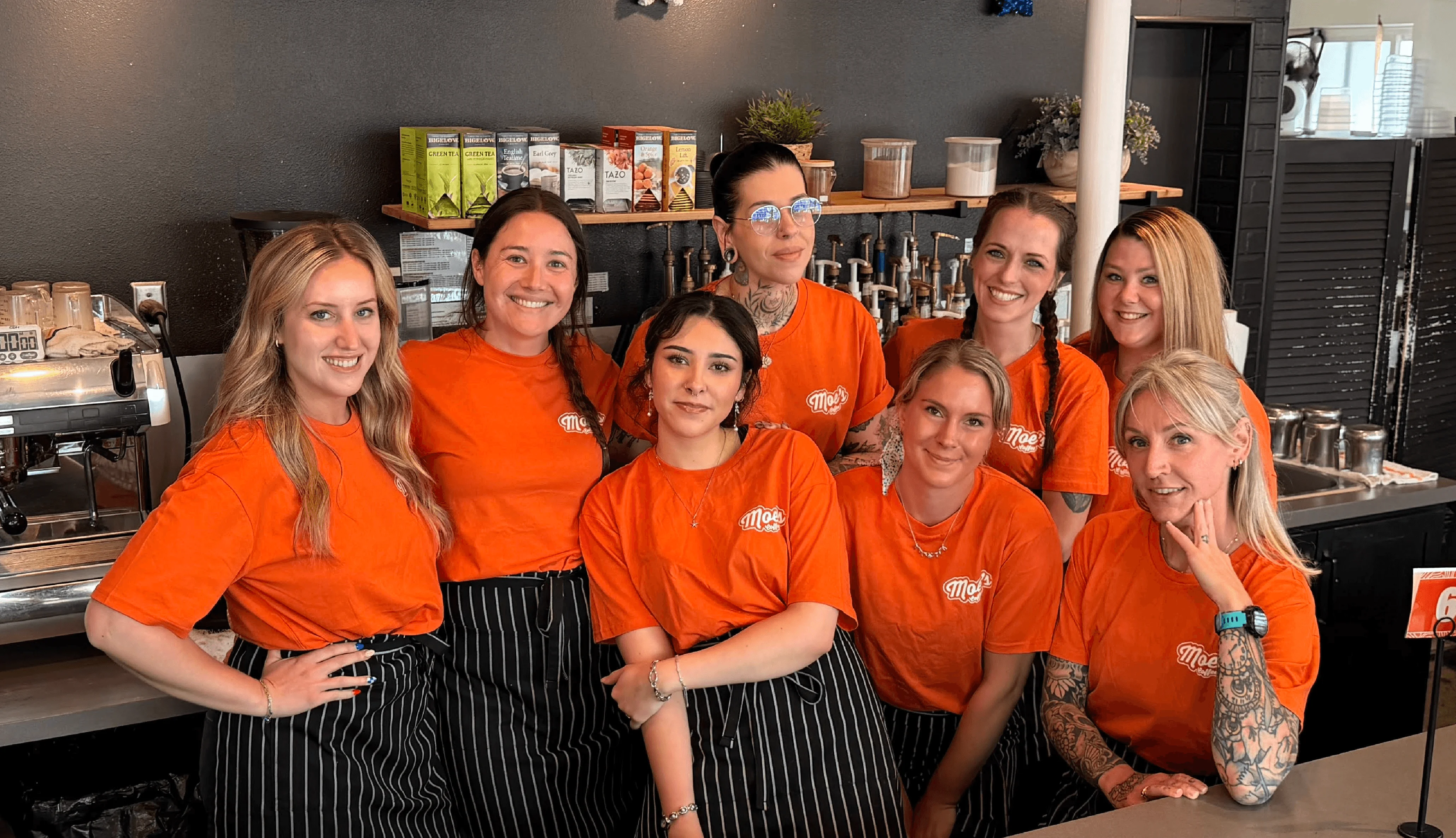 Team of baristas in orange shirts at a coffee shop