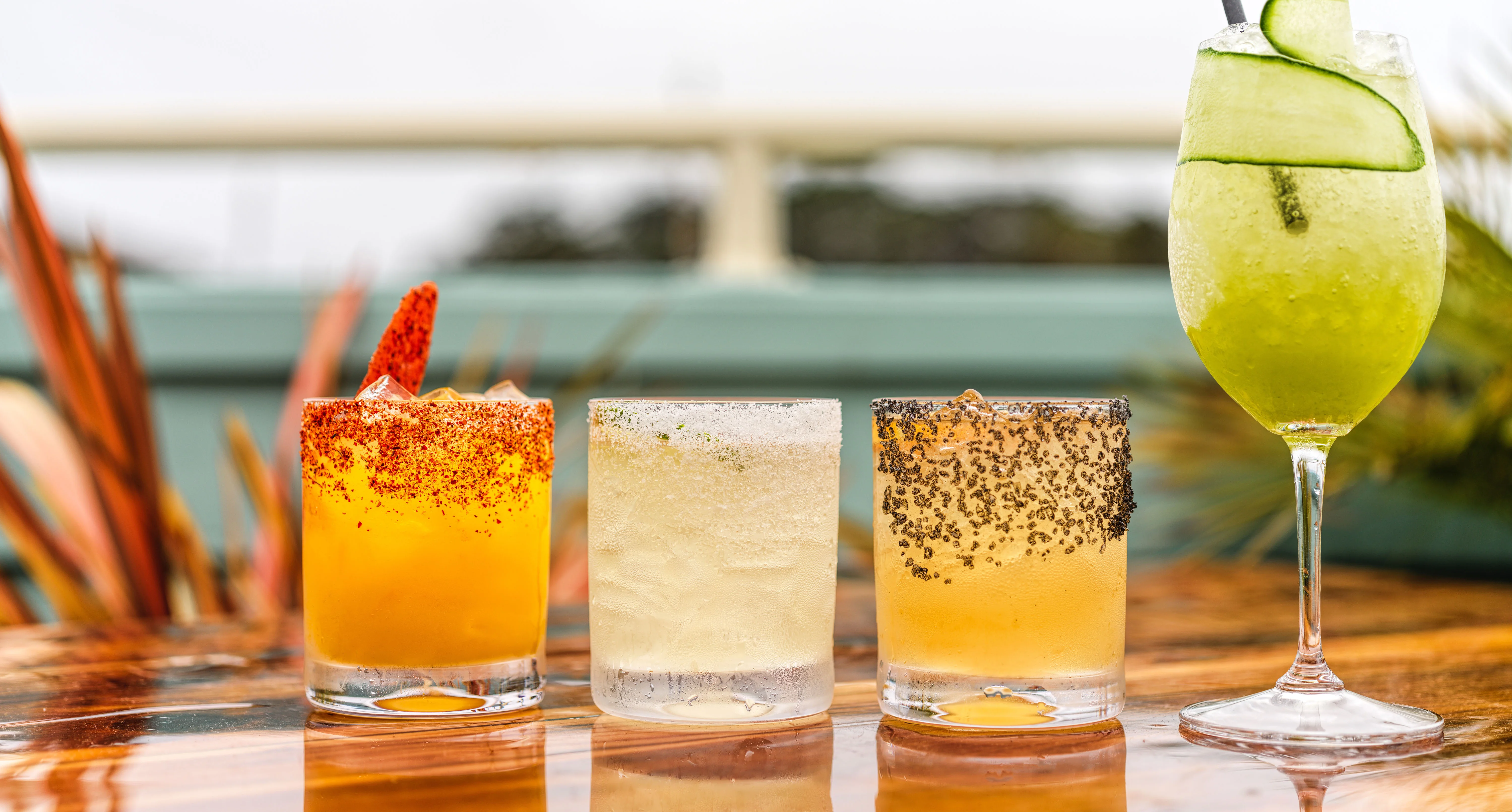 Colorful cocktails on a wooden table at a vibrant bar