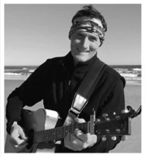 Musician playing guitar on the beach