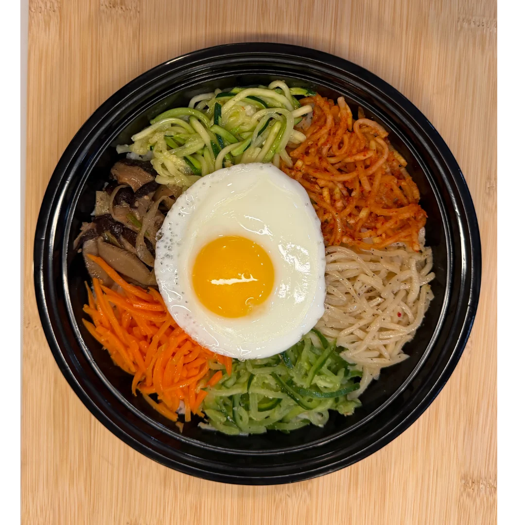 Colorful Korean bibimbap topped with a fried egg