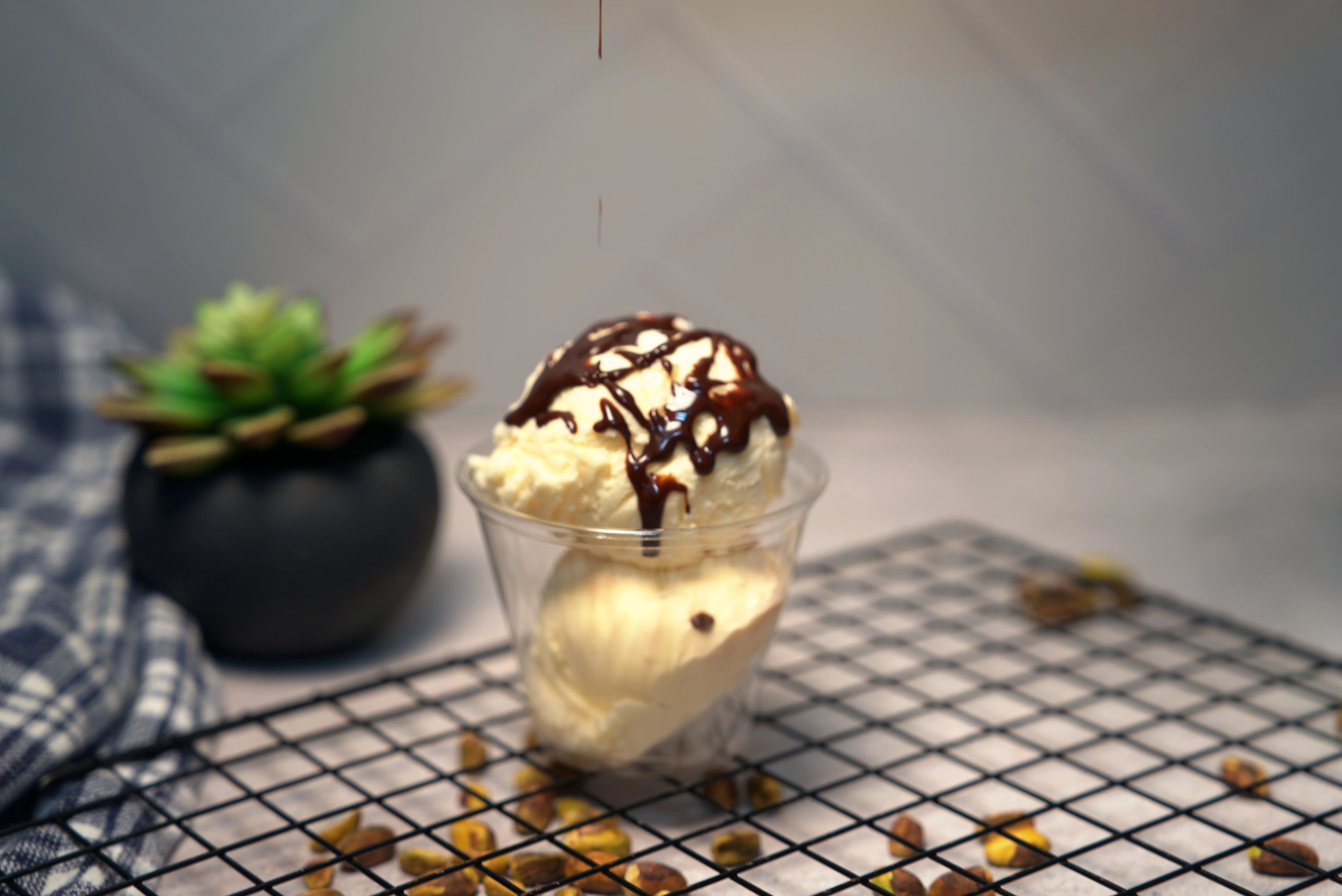 A person capturing a picture of beautifully arranged desserts in white bowls. The desserts feature a glaze and are surrounded by a sprinkle of yellow toppings.