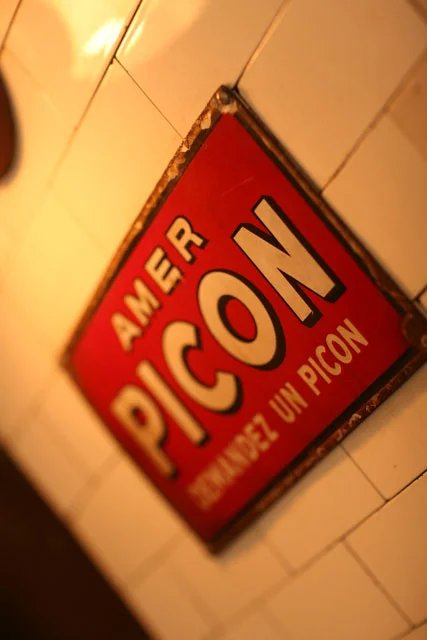Vintage signage for Amer Picon in a rustic restaurant setting