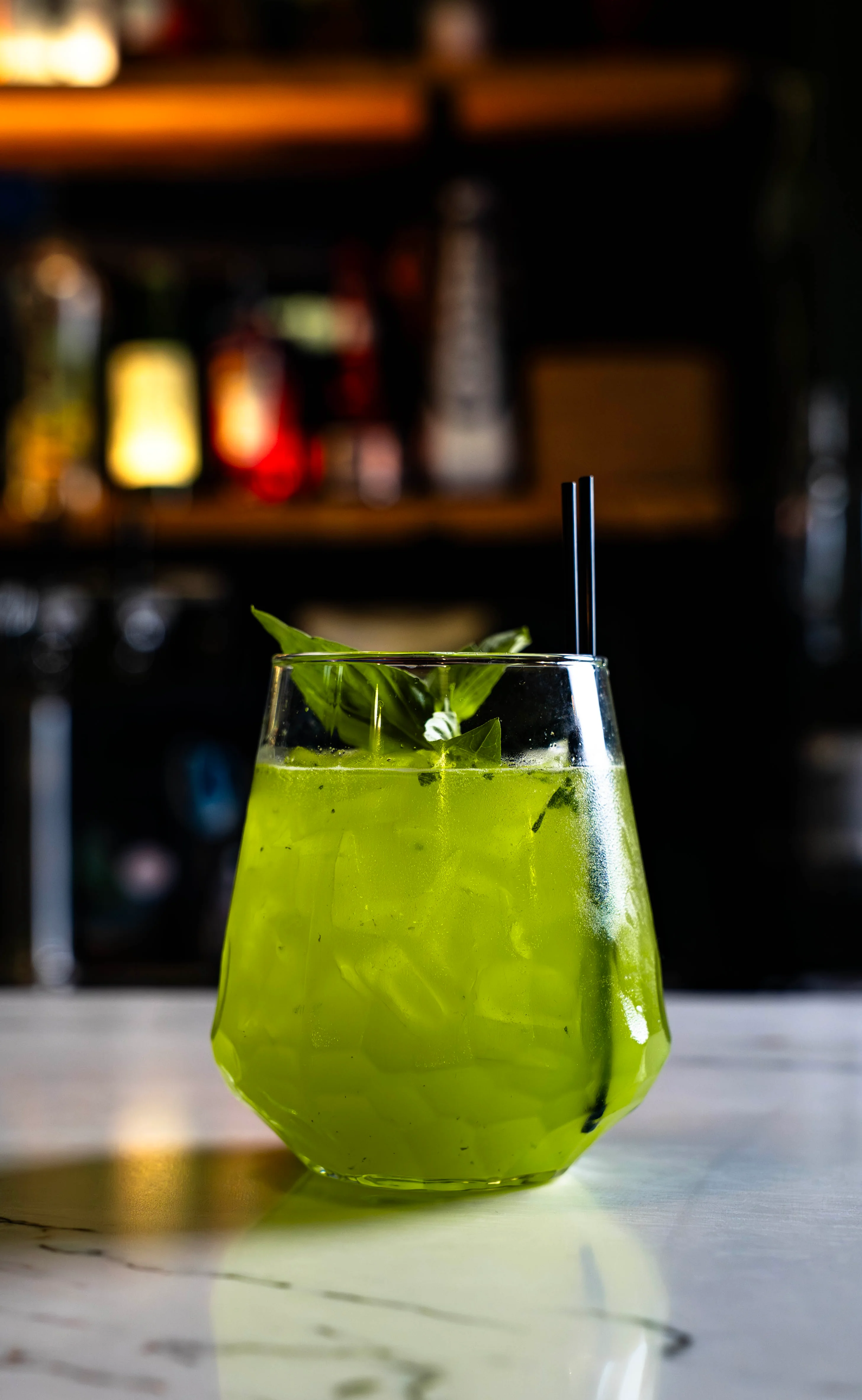 Colorful cocktail served in a glass with garnishes on a wooden table.
