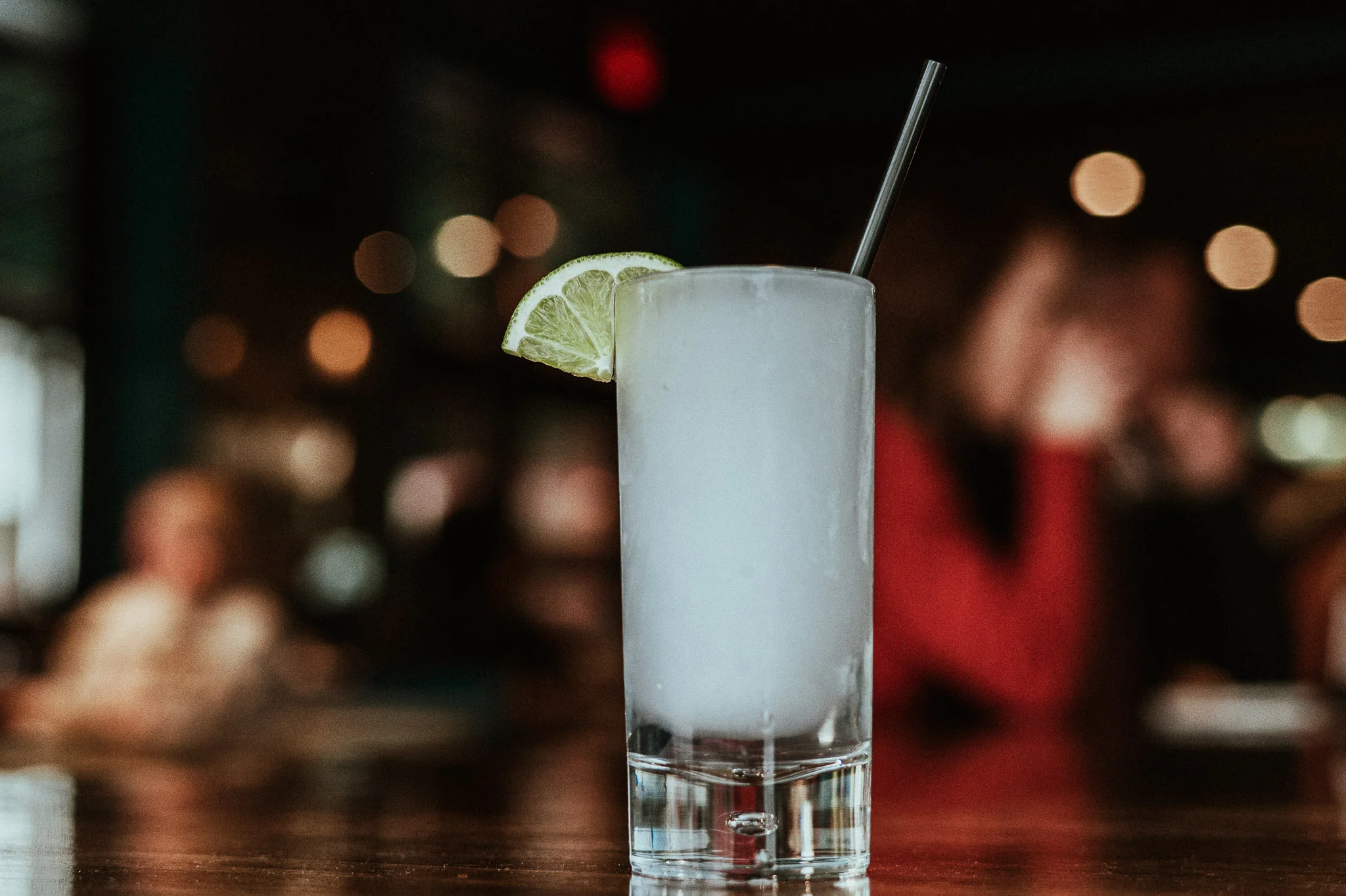 Refreshing cocktail with lime garnish in a modern bar setting