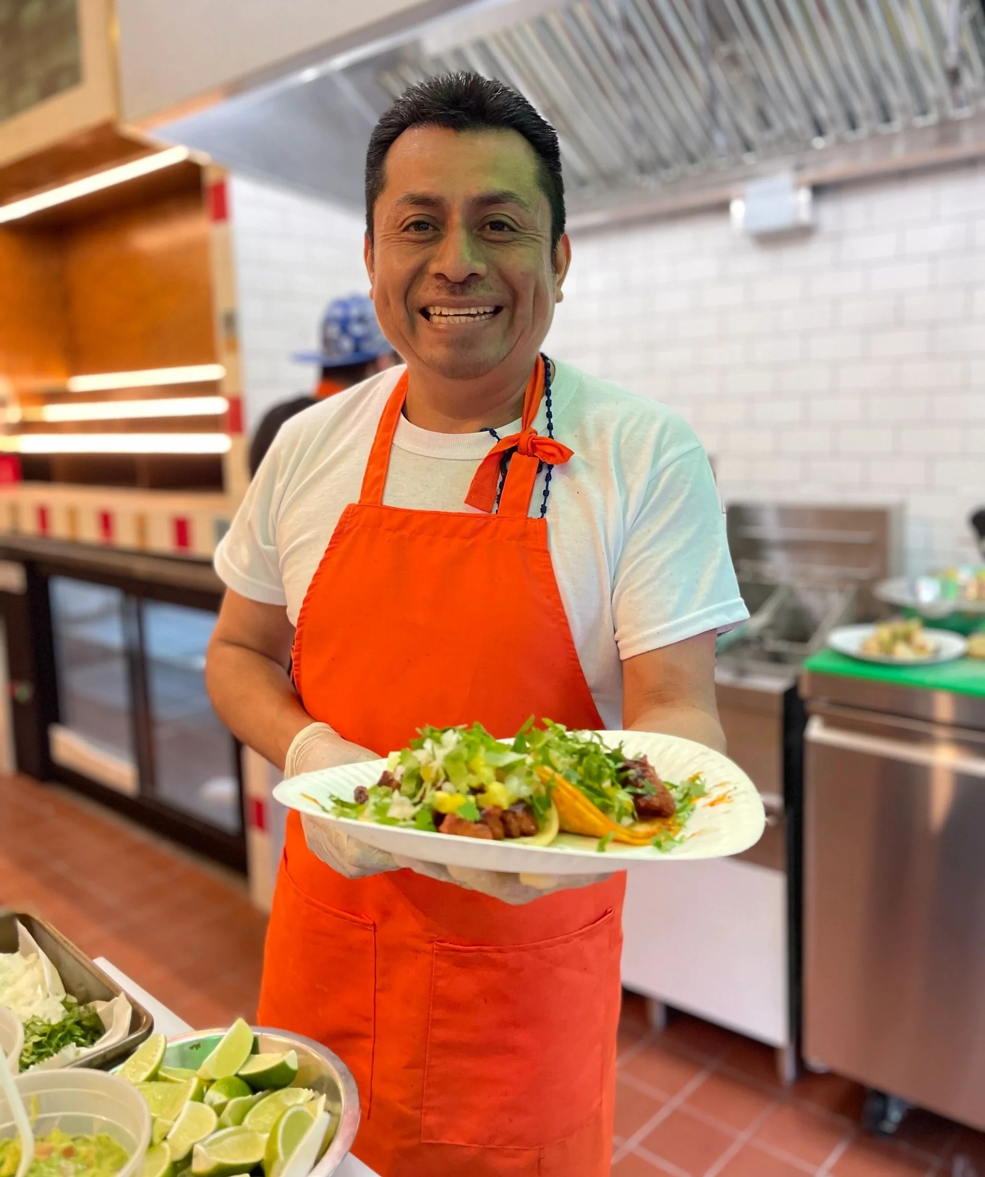 Chef presenting vibrant Mexican tacos with fresh toppings