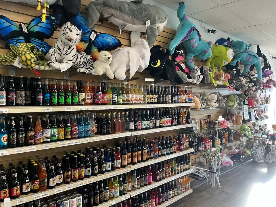 Colorful display of plush toys and soda bottles in a retail store