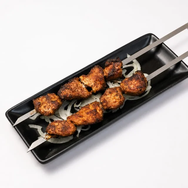 Grilled chicken kebabs on skewers with onions