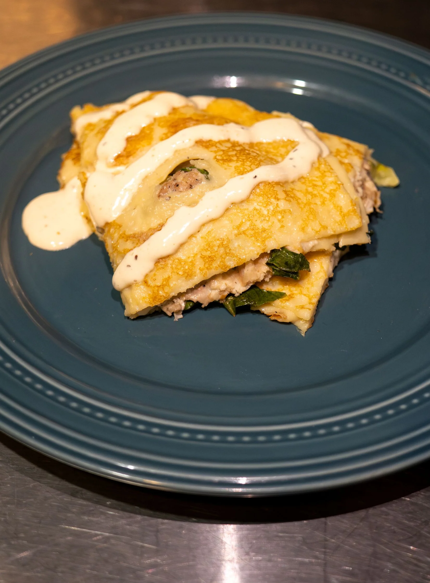 Savory Mexican enchiladas topped with creamy sauce on a blue plate