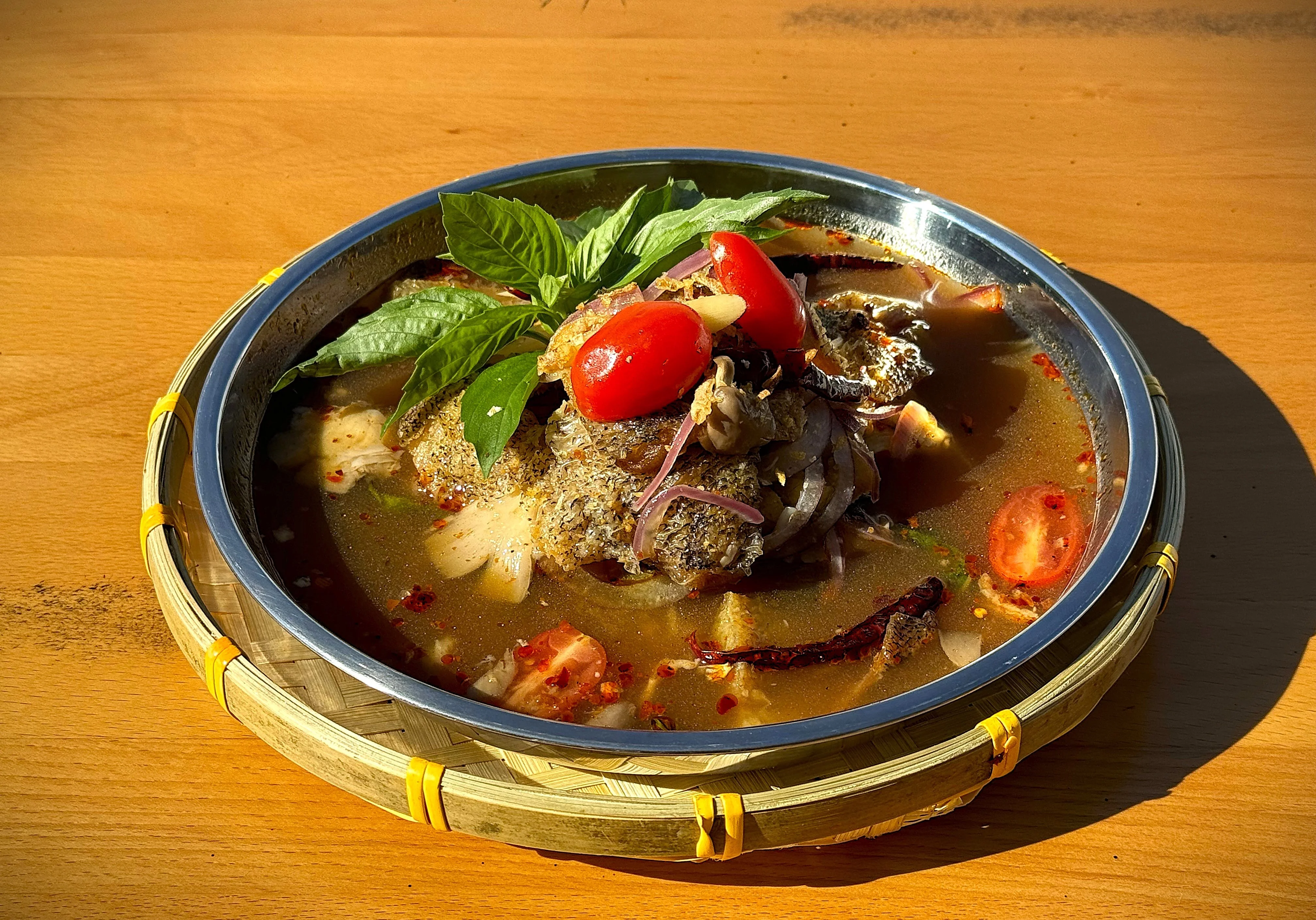 Spicy Thai fish soup with fresh herbs and vegetables