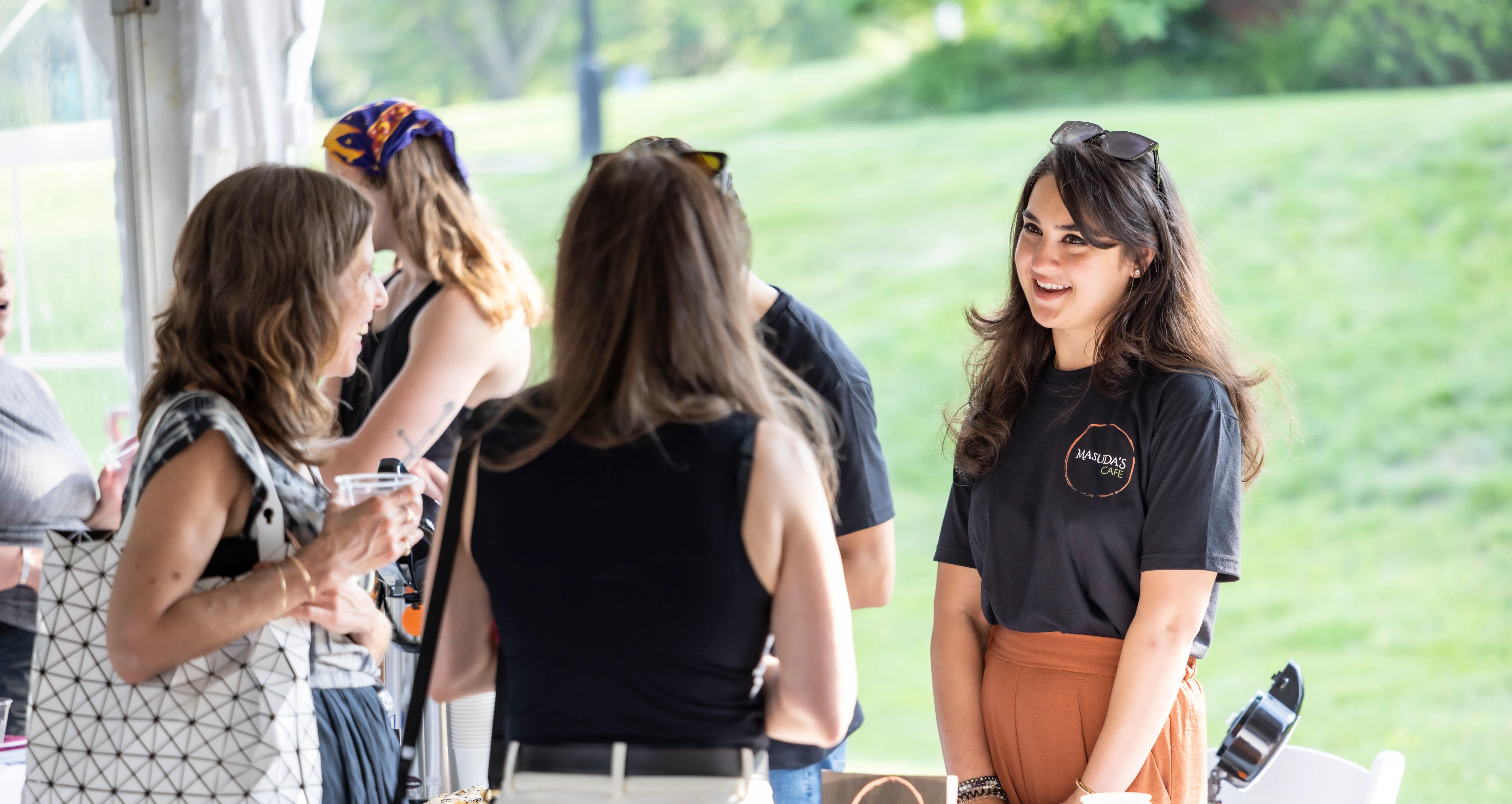 Friendly staff at a food event promoting Masuda's Cafe