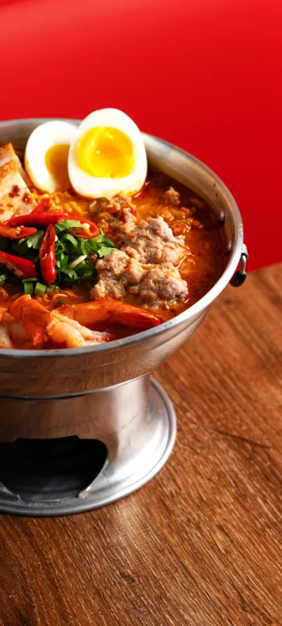 Spicy Thai tom yum seafood soup with fresh herbs
