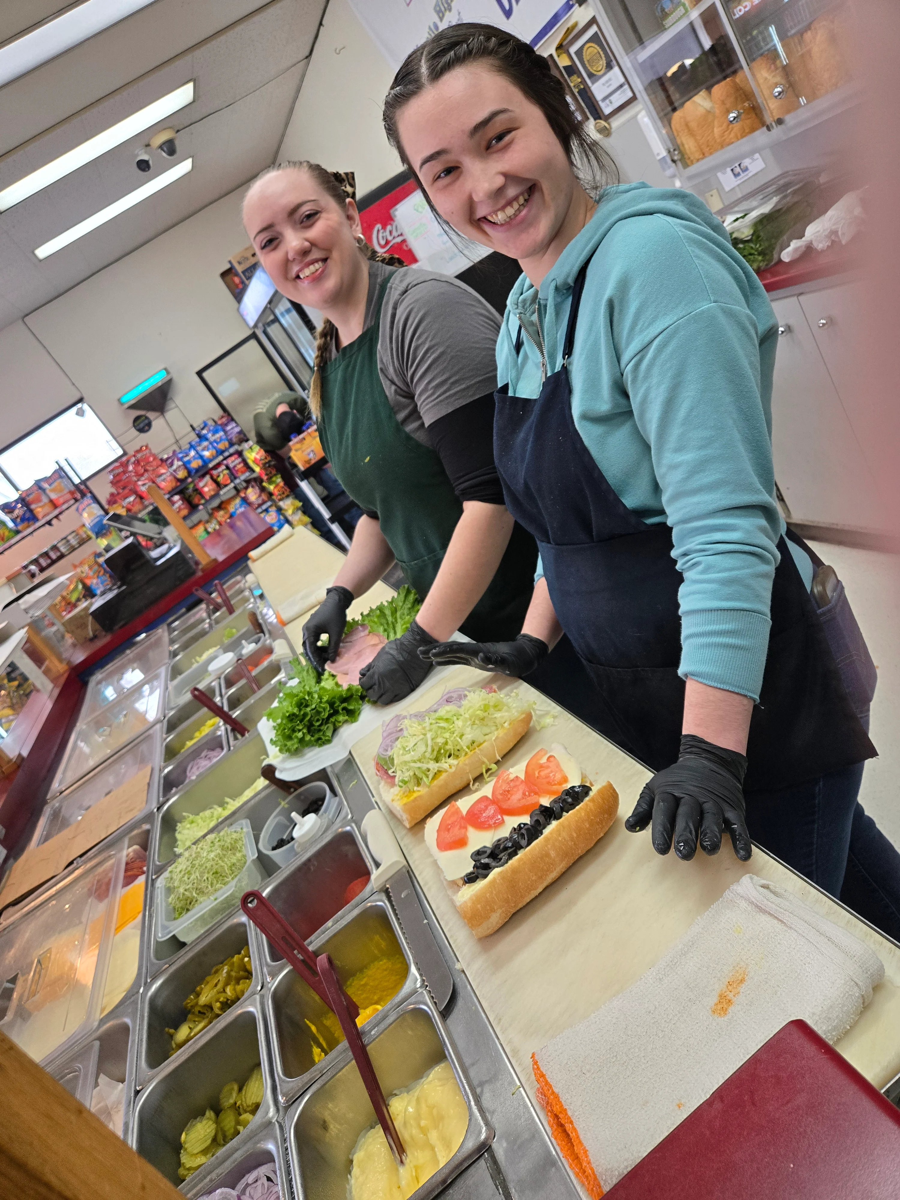 Sandwich preparation at a deli with fresh ingredients