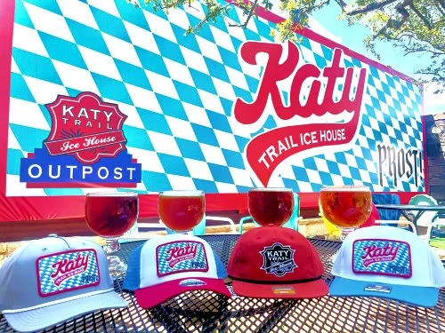 Katy Trail Ice House exterior with rustic stone wall and illuminated open sign