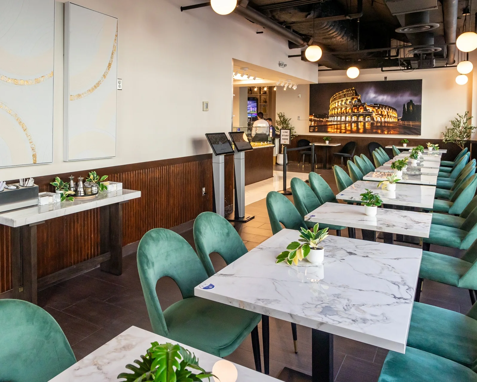 Modern restaurant interior with green chairs and marble tables