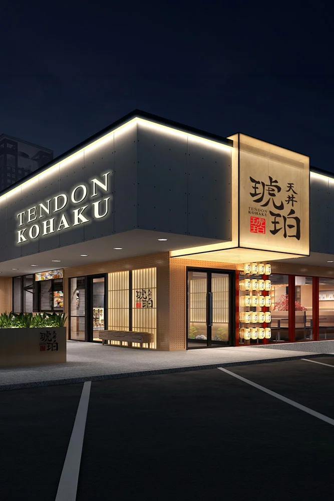 The storefront of Tendon Kohaku at night, featuring a contemporary dark facade with illuminated white signage.